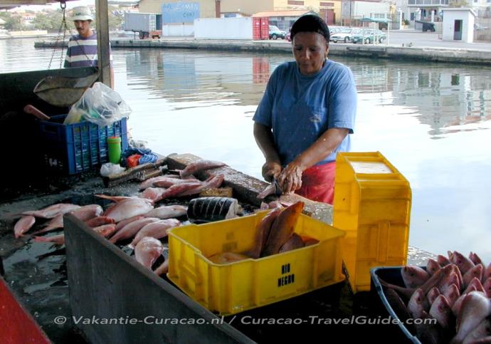 Fish market - Woman cleans the fish
